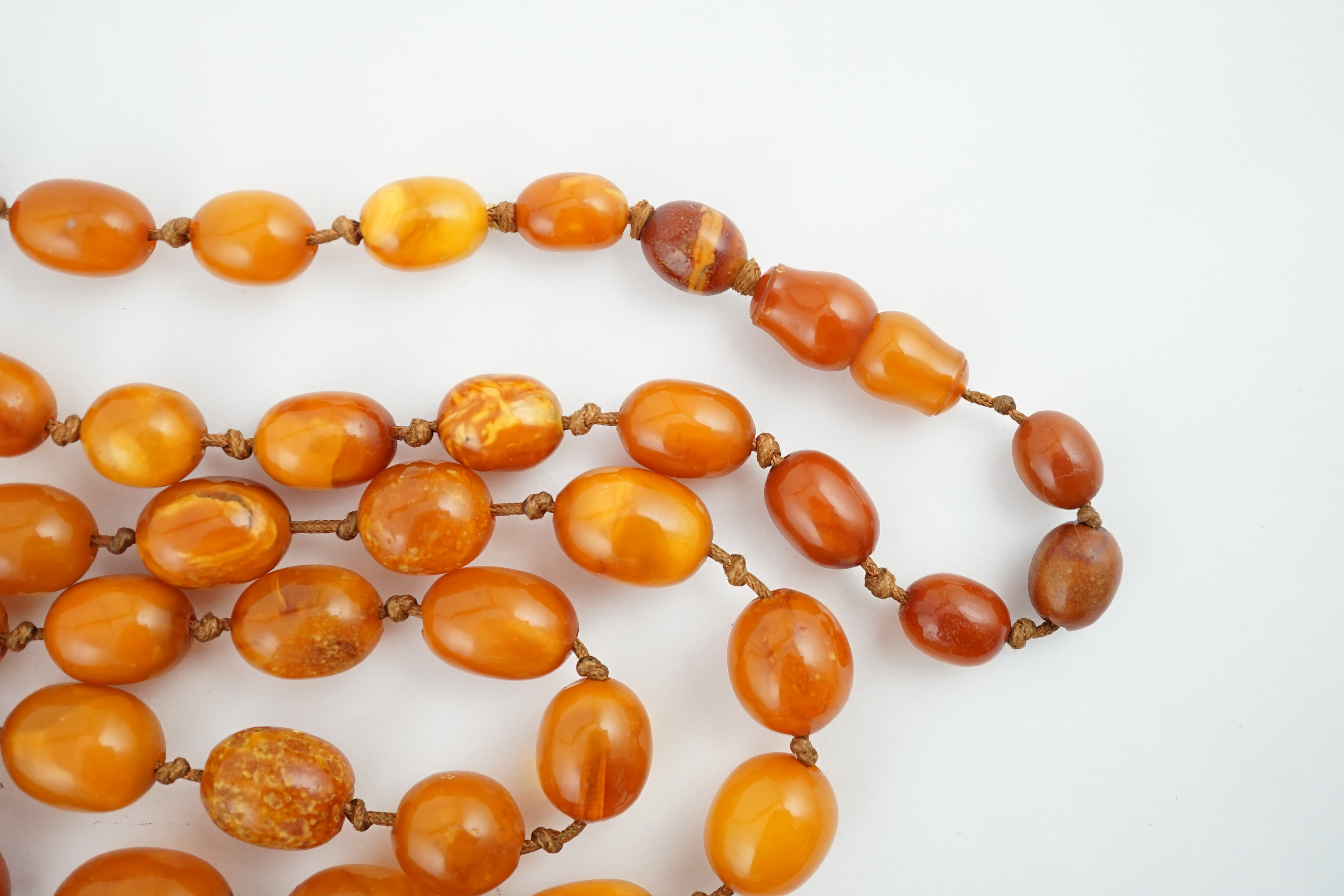 A long single strand graduated amber bead necklace